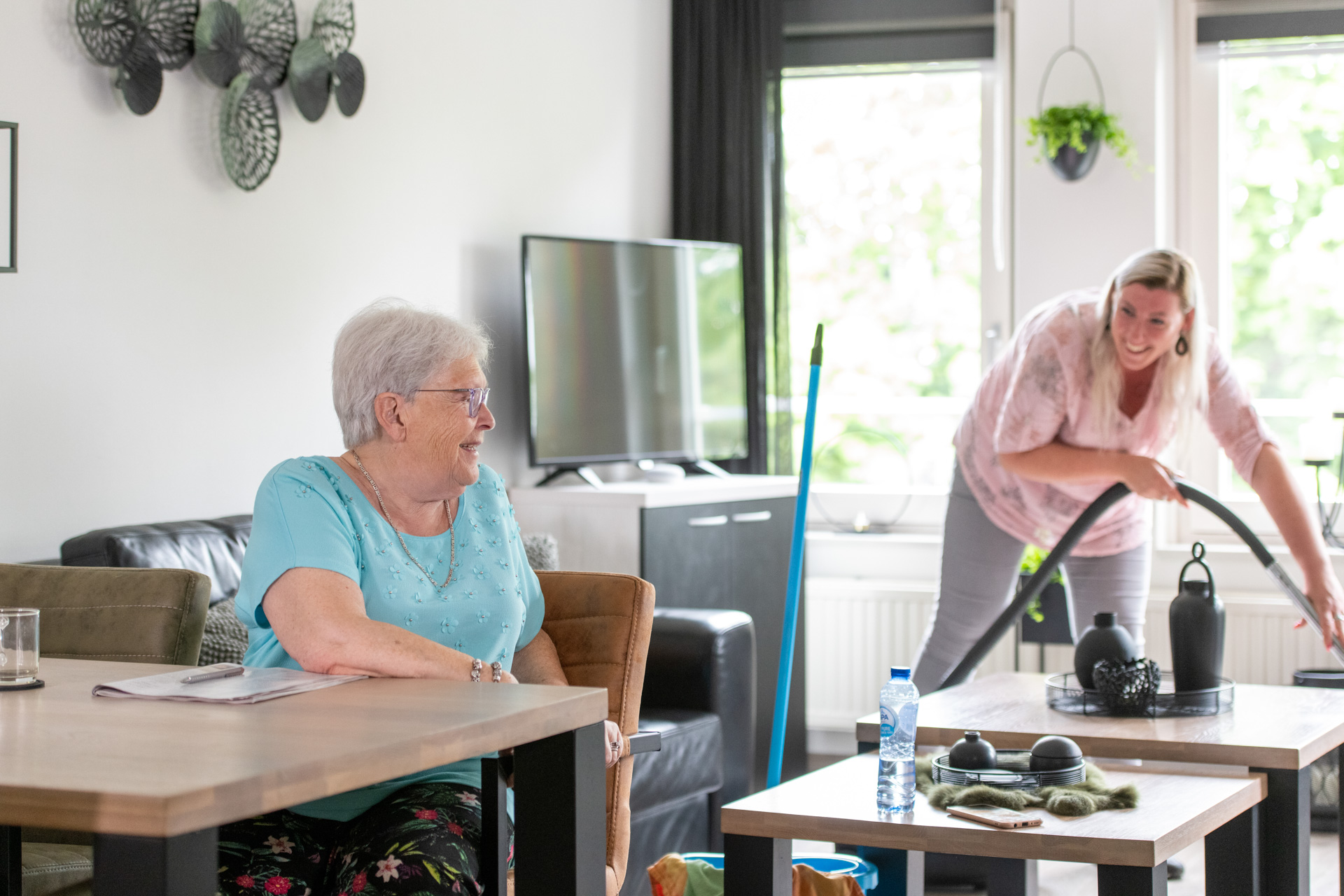 Medewerkster aan het stofzuigen en klant
